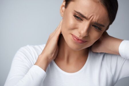 Dieses Bild veranschaulicht eine junge Frau mit Kopfschmerzen vom Nacken bis zur Stirn.